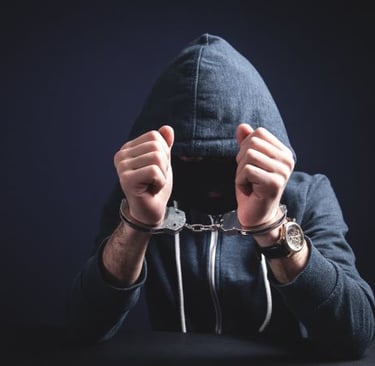 a man in a hoodie with handcuffs and handcuffs