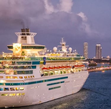 a cruise ship in the water with a city in the background