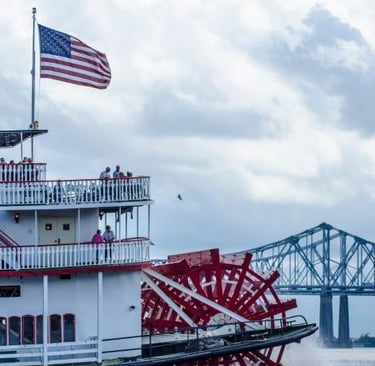 a paddle boat with a flag on it on the mississipi river