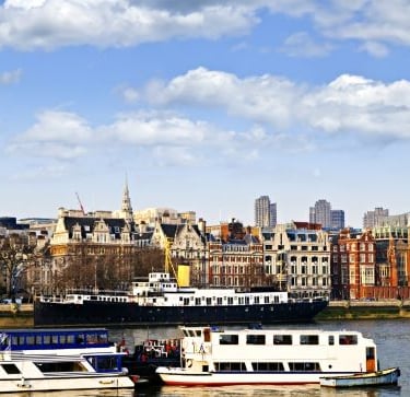 a boat on the water with a city in the background