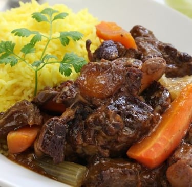 a plate of food with rice, meat and vegetables