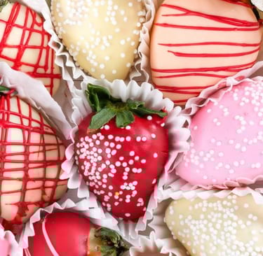 a box of chocolate covered strawberries with white and red sprinkles