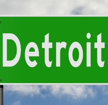 a green street sign with the word detroit