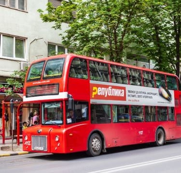 a red double decker bus parked on the side of a street