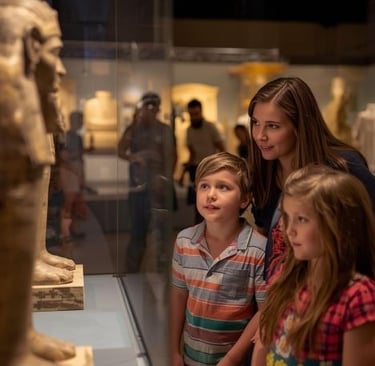 a woman and two children in a museum