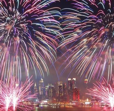 fireworks in the sky over a city skyline