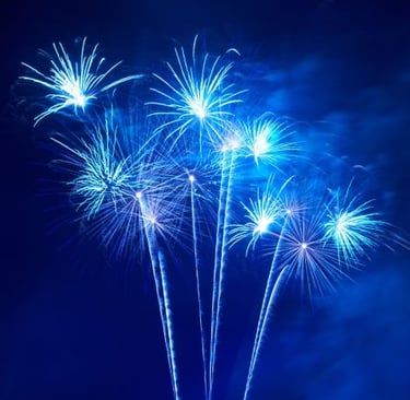 a bunch of fireworks in a blue sky