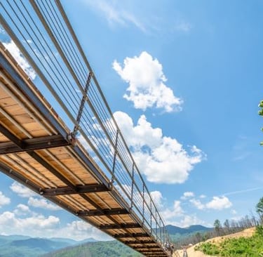 a bridge crossing a river in the mountains
