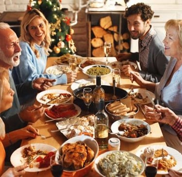 a group of people sitting around a table with food