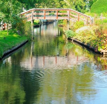 Giethoorn - a bridge over a river with a bridge over it