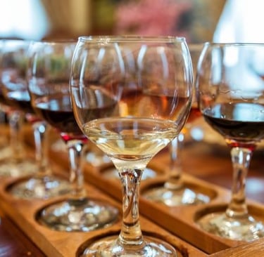 a row of wine glasses with wine glasses on a table