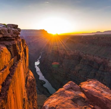 a man standing on a cliff overlooking a river