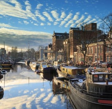 groningen - a river with boats and buildings in the background