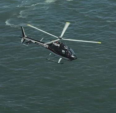 a helicopter flying over a body of water