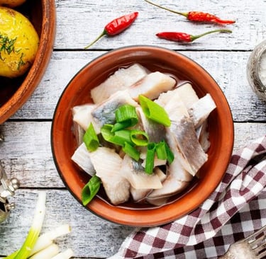 a bowl of fish with a spoon and a fork