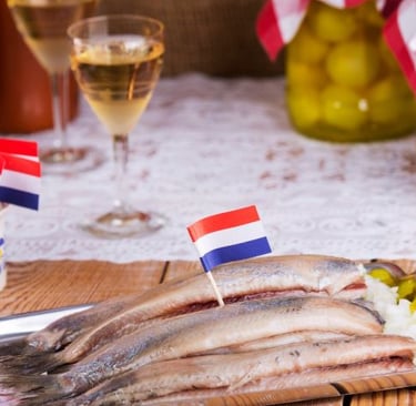 Traditional Dutch soused herring served with onions and Dutch flag toothpicks alongside white wine.
