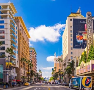 hollywood - a city street with a bus and cars parked on the side of the road