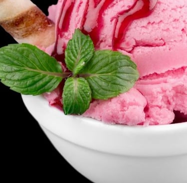 a bowl of ice cream with a mint green leaf