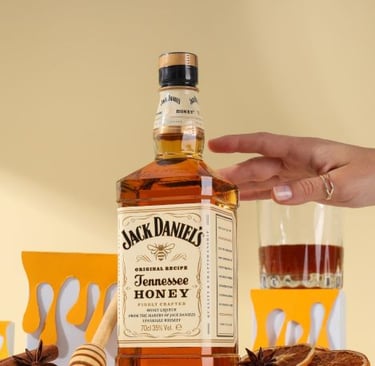 a person holding a bottle of whiskey and a glass of honey