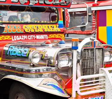 a colorful bus parked in front of a building