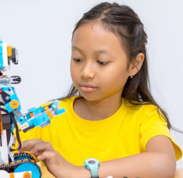 a young girl is playing with a robot toy