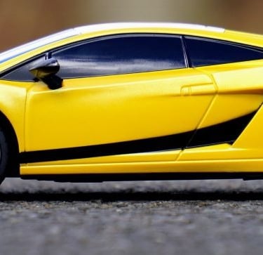 a yellow lambo car with a black and white stripe