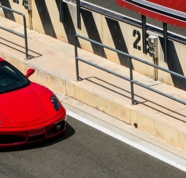 a red sports car driving down a street