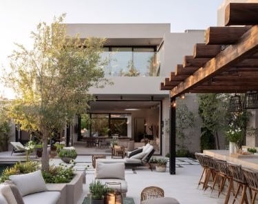 a patio at a luxury hotel with a fireplace and a table with chairs