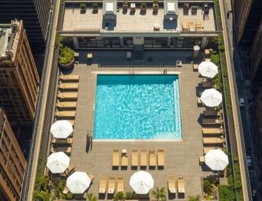 a swimming pool and lounge chairs at a luxury hotel in new york city