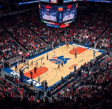 A crowded indoor basketball arena during a professional game with fans in red seating.