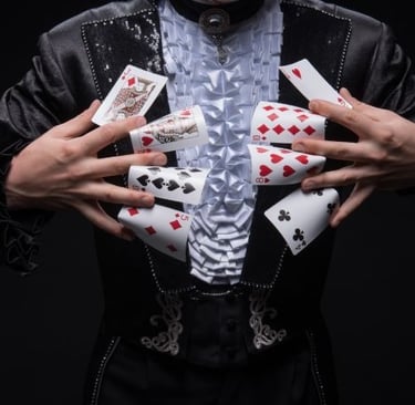 a man in a black suit and a white shirt holding playing cards