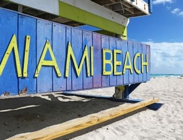 a blue and yellow sign that says miami beach