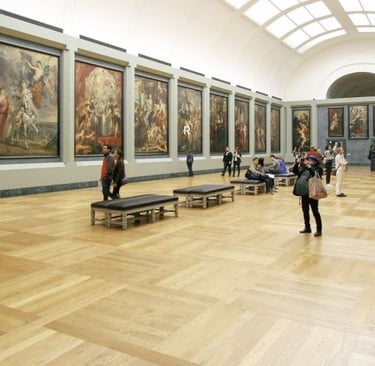 Visitors view large classical oil paintings in a bright art museum gallery with parquet floors.