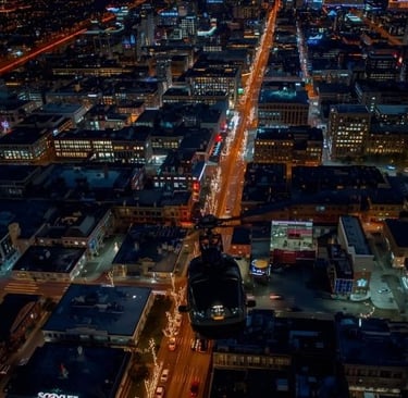 a helicopter flying over a city at night
