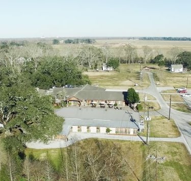 oak alley - a large building with a lot of trees and a lot of grass