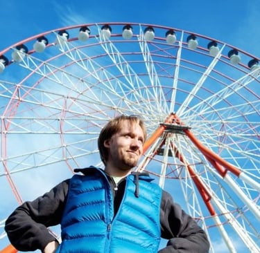 a man standing in front of a ferris wheel