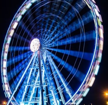 a ferris wheel with a ferris wheel in the middle of a dark night