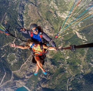 a man and woman parasailing in a parachute