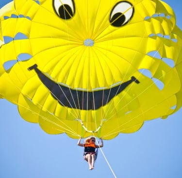 a person parasailing a parachute with a smile face