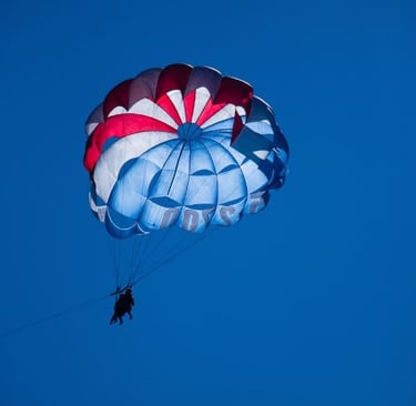 a person parasailing a parachute in the sky