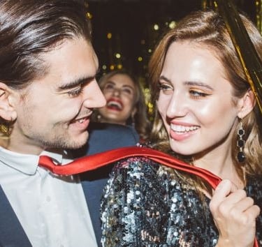 a man and woman standing in front of a party