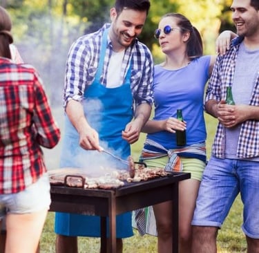 a group of people standing around a grill