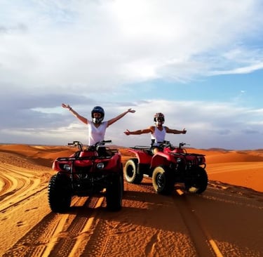 two people riding quad - atvs in the desert