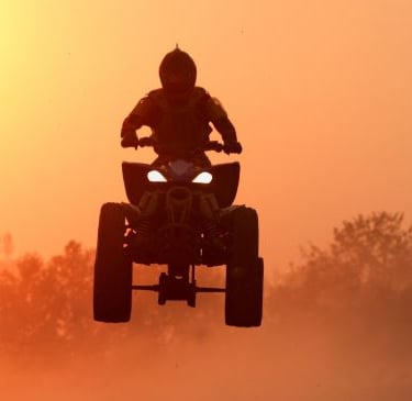 a person riding a quad - atv atv in the sun
