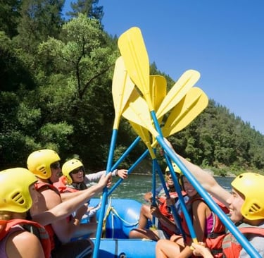 Raft navigating Class III rapids on the turbulent Ocoee River with spray flying.
