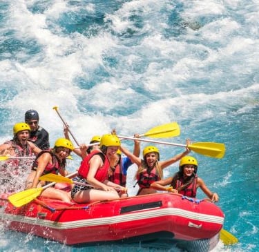a group of people rafting down a river