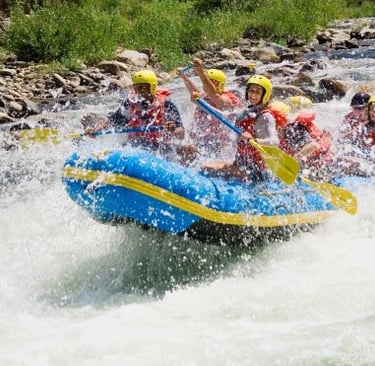 a group of people rafting down a river