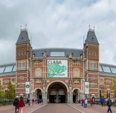 The Rijksmuseum in Amsterdam featuring the Clara rhinoceros exhibition banner on its historic facade.