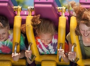 a woman and her two children on a roller coaster