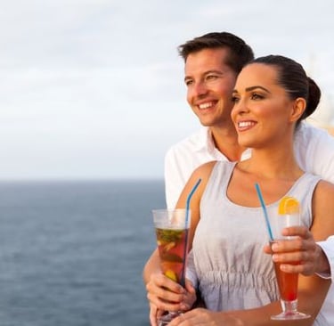 a man and woman holding drinks on a cruise ship